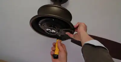 Electrician installing ceiling fan mounting bracket and fixture in San Francisco, CA