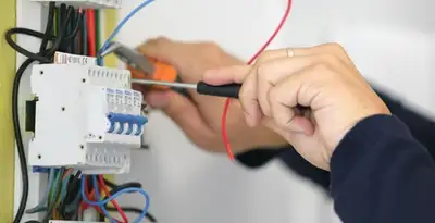 Electrician installing and adjusting circuit breakers in an electrical panel in San Francisco, CA