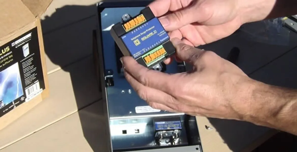 Electrician installing whole home surge protection unit inside main electrical panel in San Francisco, CA