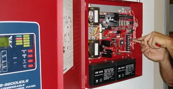 fire alarm installation service showing technician configuring fire alarm control panel in San Francisco, CA