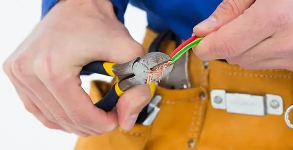 licensed electrician securing electrical wiring with professional tools during service work in San Francisco, CA