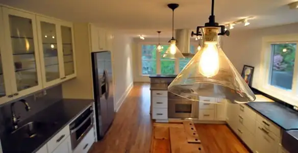 Residential electrician installing modern indoor light fixture in a home in San Francisco, CA